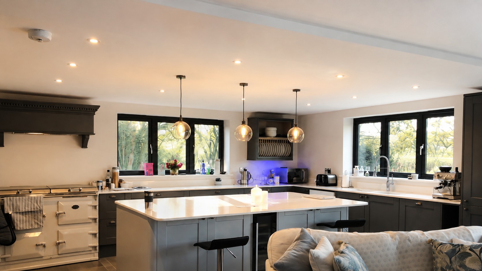 Open-plan kitchen with downlights and pendant lights
